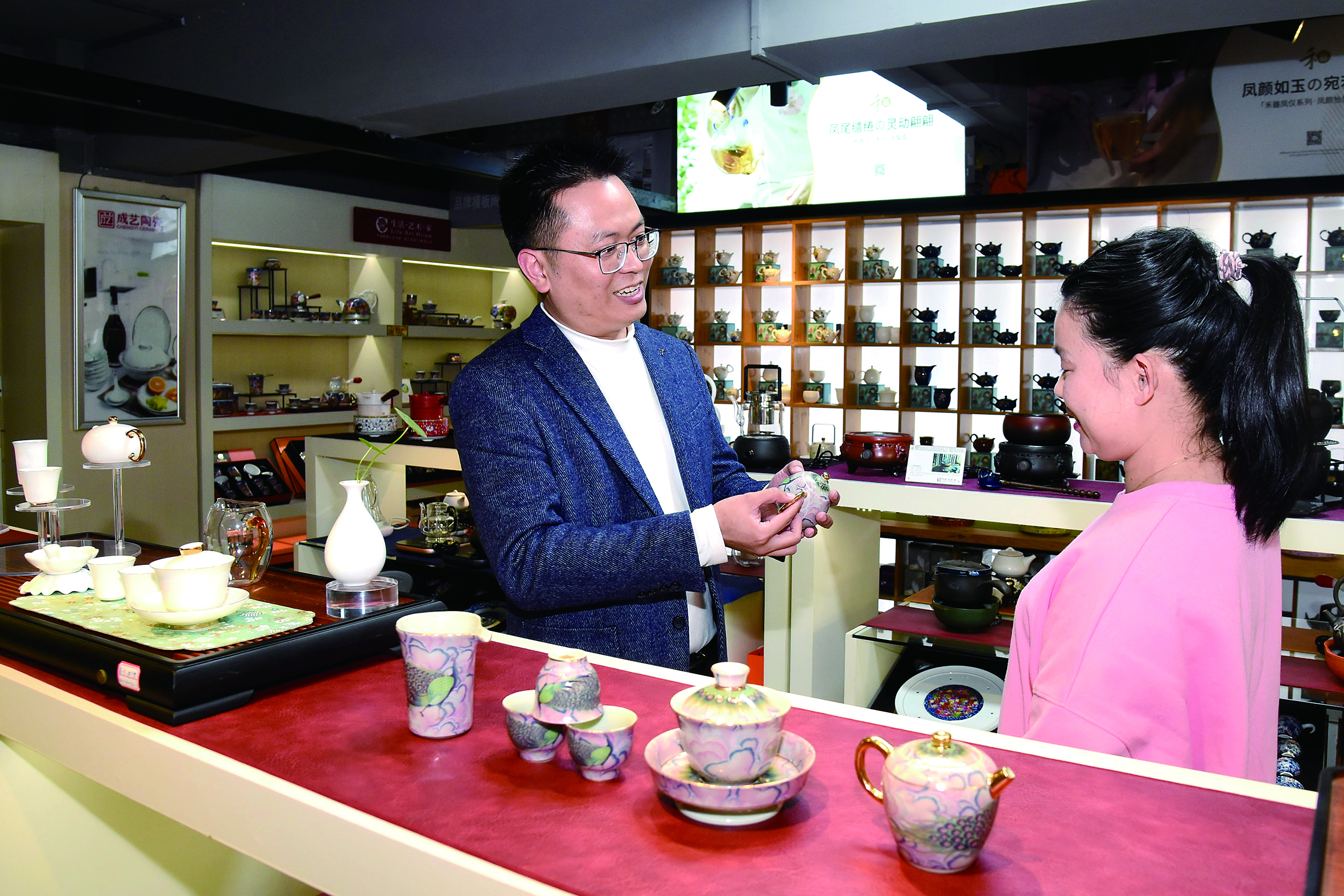 颜东强给客户介绍《孔雀开屏》系列茶具.JPG